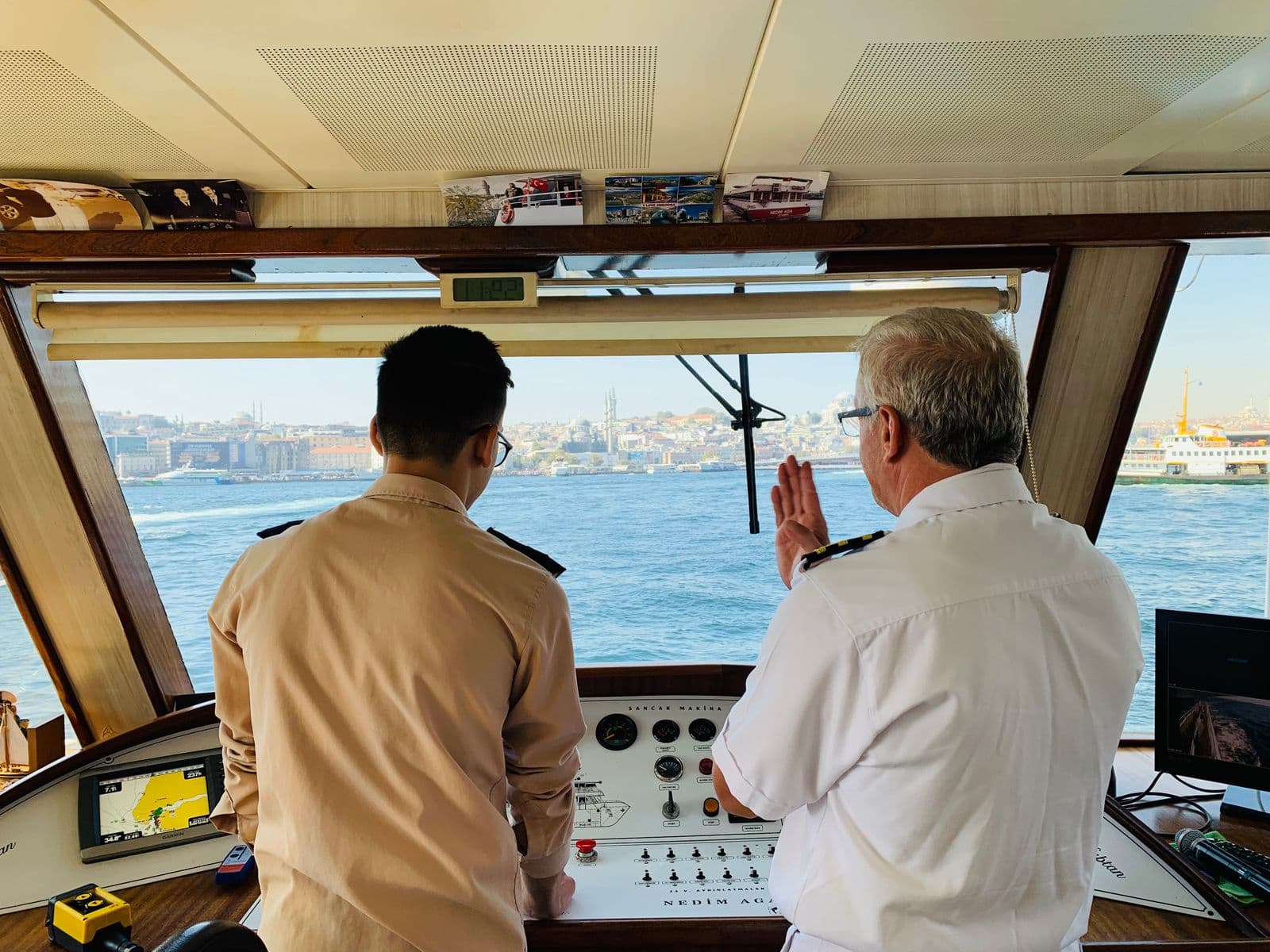 Ship's officer and crew member reviewing navigation on the bridge